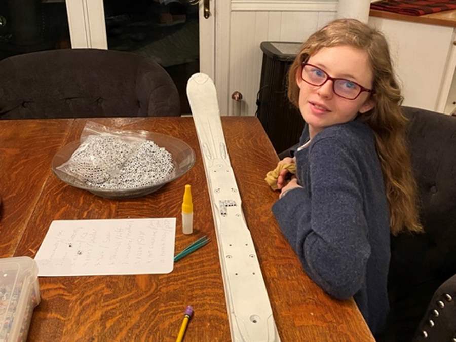 Girl making artwork on a ski for fundraiser 